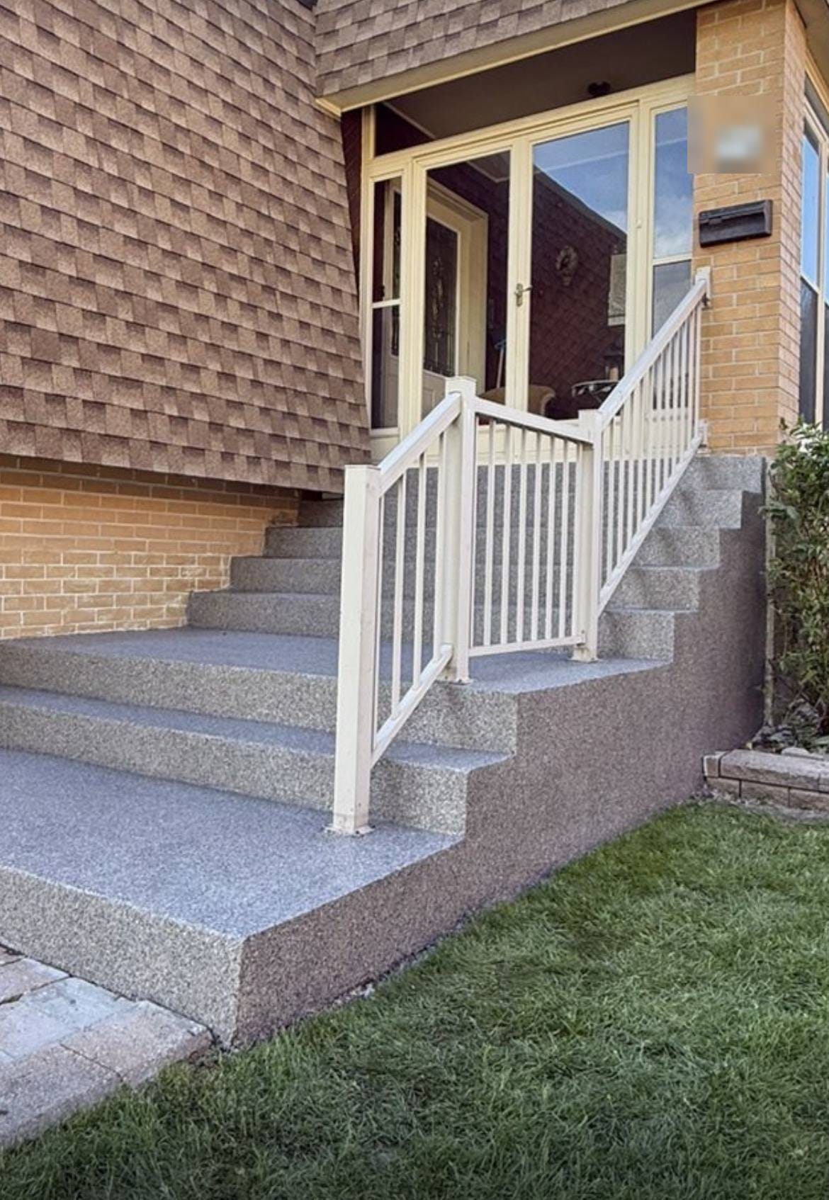 A Scarborough porch and full flight of steps rebuilt and finished in a granite-look flake system, white railings reinstalled