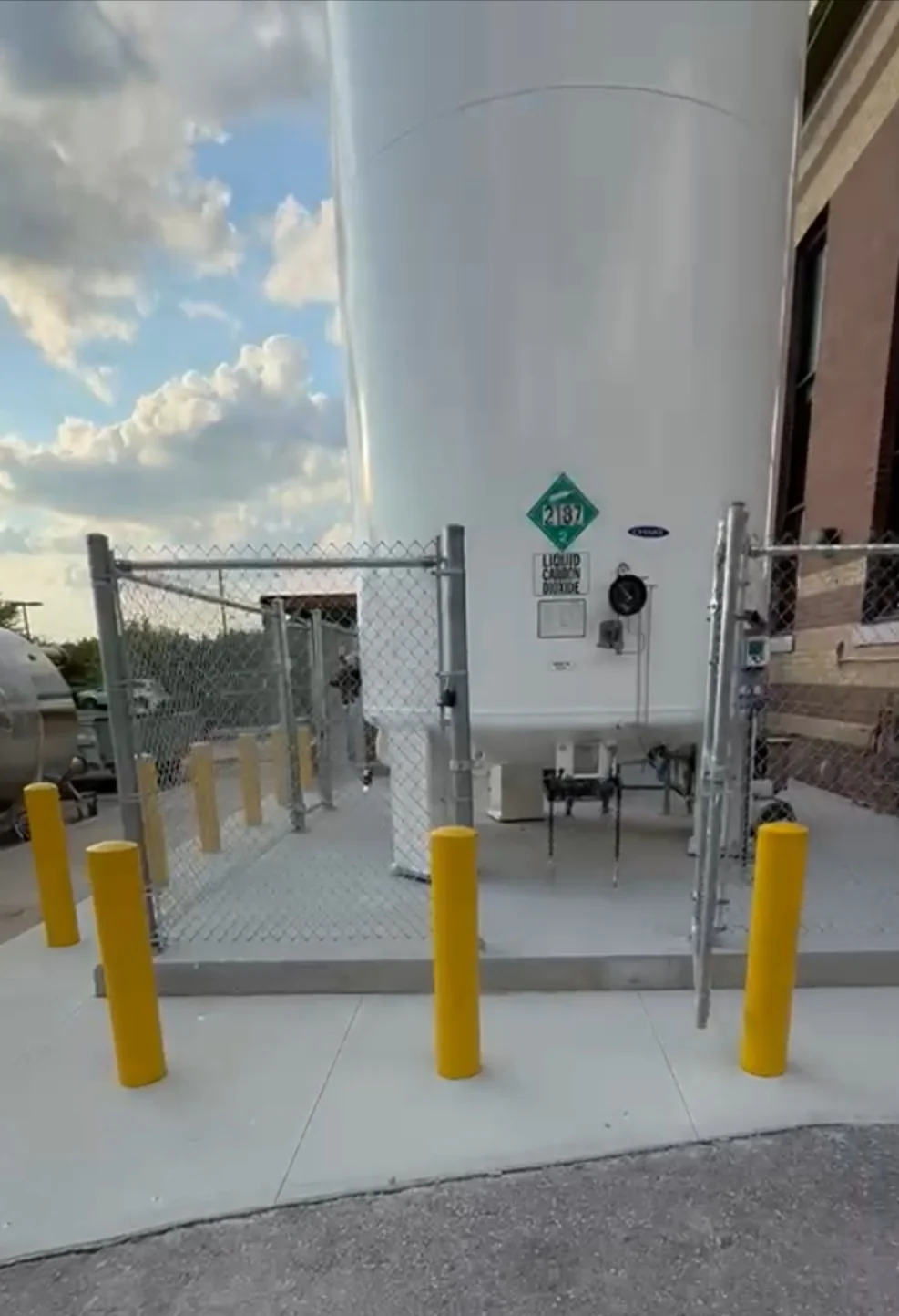 Finished engineered concrete equipment pad with bollards and protective fencing — the same construction discipline we bring to EV charger bases across Toronto and the GTA.